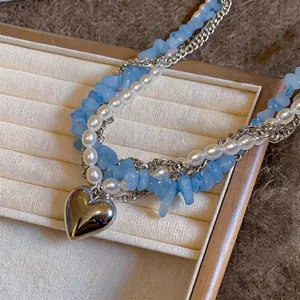 Collier multicouche élégant avec pierres bleues, perles et pendentif coeur argent.