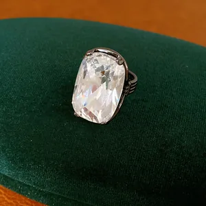 Nahaufnahme eines übergroßen rechteckigen Edelsteinrings mit gestreiftem Band