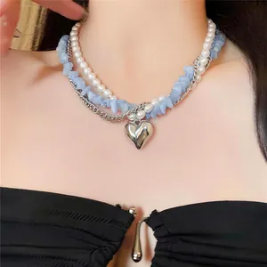 Gros plan d'un collier élégant à pendentif cœur multicouche avec perles et perles bleues