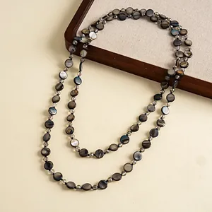 Macro view of retro layered necklace with dark shell and glass beads on display