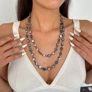 Detailed view of retro double-layered shell bead necklace with iridescent round glass discs