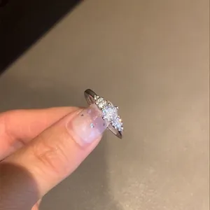 Gedetailleerde opname van een Franse zilveren ring met ronde zirkonia op een hand gepresenteerd.