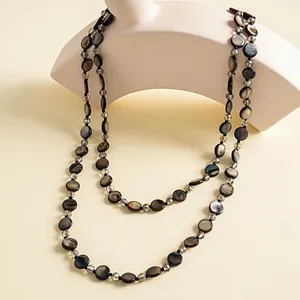 Macro view of vintage iridescent shell disk and crystal beaded layered necklace