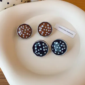 Gedetailleerd zicht op elegante retro ronde polkadot oorknopjes met een kristallen afwerking