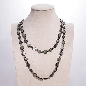 Vintage layered necklace with dark iridescent shell discs and glass beads on jewelry bust