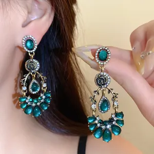 Gros plan détaillé de boucles d'oreilles vintage en résine verte et cristaux chic