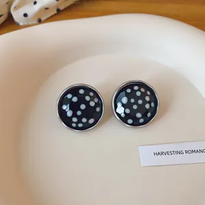 Detailopname van vintage ronde oorknopjes met zwart-witte polkadots