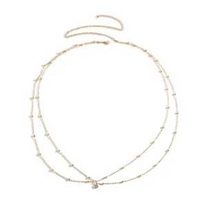 Close-up of double-layer gold bead waist chain with a sparkling diamond pendant.