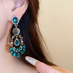 Gros plan détaillé de boucles d'oreilles de style palais avec résine verte