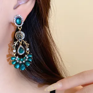 Boucles d'oreilles style cour vintage avec pierres en résine verte et strass gros plan