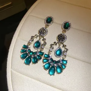 Gros plan de boucles d'oreilles vintage en résine vert émeraude avec motif goutte