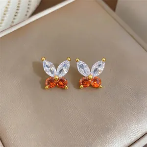 Detailansicht von Schmetterlingssteckern mit weißen und orangefarbenen Steinen