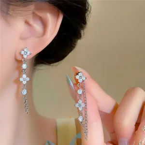 Nahaufnahme von eleganten silbernen Kleeblatt-Ohrringen mit funkelnden Zirkonia.