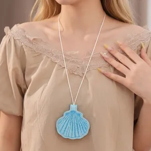 Stylish blue leather shell pendant necklace on white cord shown on a fashion model