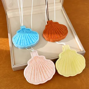 Detailed view of four colorful shell-shaped leather eyeglass clips in an elegant box