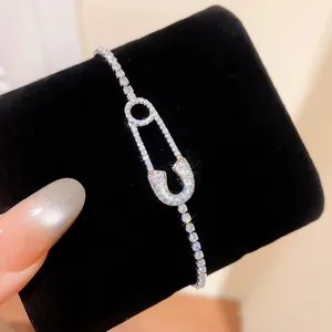 Primer plano de pulsera de circonita con forma de imperdible sobre terciopelo negro