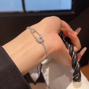 Primer plano de una pulsera de imperdible con circonitas brillantes en la muñeca mujer