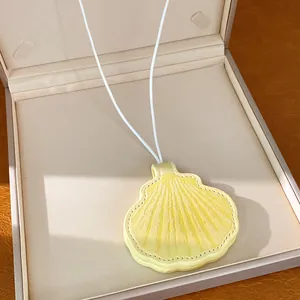 Close-up of yellow leather shell pendant necklace resting in a premium jewelry box