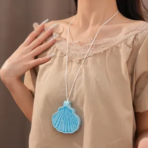 Detailed view of a light blue leather seashell eyeglass holder pendant necklace on model