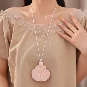 Detailed view of a seashell-shaped leather necklace worn as a stylish fashion accessory