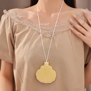 Detail of a yellow leather shell-shaped eyeglass holder necklace worn by a model