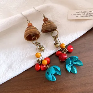 Nahaufnahme von Vintage-Holzohrringen im ethnischen Stil mit bunten Perlen und Blüten