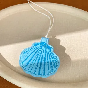 Detailed close-up of a light blue leather seashell pendant necklace with elegant white cord