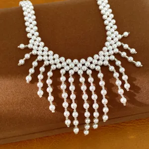 Primer plano de un elegante collar de perlas con borlas y detalles de cuentas estilo palacio.