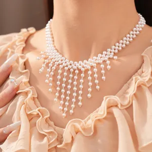 Primer plano detallado de elegante collar de borlas de perlas blancas de varios hilos en modelo