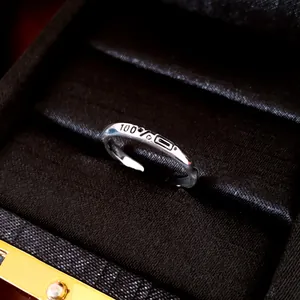 Macro view of a minimalist silver adjustable ring featuring 100% battery icon engraving