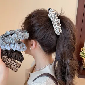 Detail van een vintage bananenclip met luipaardprint in de paardenstaart van een model.