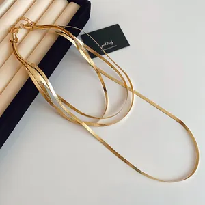 Détail d'un collier à plusieurs rangs en maille serpent dorée au fini métallique lisse