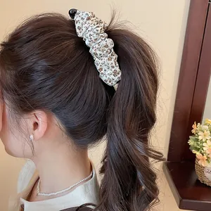 Detailopname van een vintage geplooide haarklem met luipaardprint in een paardenstaart