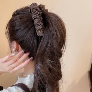 Detail van een vintage bananenclip met mesh luipaardprint in een paardenstaart