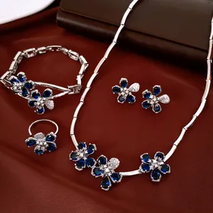 Detalle exquisito de un conjunto de joyas de plata con motivos florales de circón azul