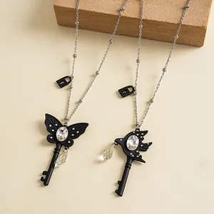 Detailweergave van donkere vlinder- en vogel-sleutelhangers met glazen strass-steentjes.