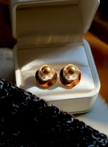 Detailweergave van vintage goudkleurige pareloorknopjes met emaille en geschenkdoos