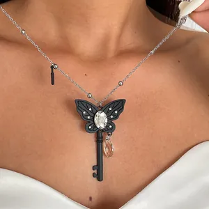 Detail van donkere vlindersleutel ketting met kristallen en glazen druppel hanger
