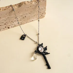 Detailweergave van een gotische zwarte zwaluw sleutelketting met heldere kristallen druppel.
