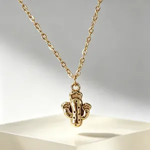 Gros plan détaillé d'un collier avec pendentif cactus doré sur un socle blanc