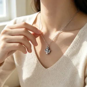 Vue détaillée d'un collier avec pendentif cactus en argent porté par un mannequin élégant