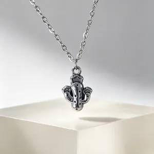 Gros plan détaillé d'un collier avec pendentif cactus en argent sur un support blanc