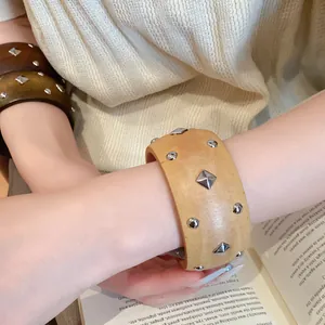 Makroansicht des Holz-Manschettenarmband im Vintage-Stil mit geometrischen Metallnieten