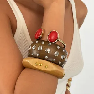 Detailansicht von Retro-Resin-Armreifen mit Metallnieten und roten Steinen am Arm