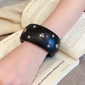 Nahaufnahme eines schwarzen Vintage-Armreifs mit silbernen geometrischen Nieten