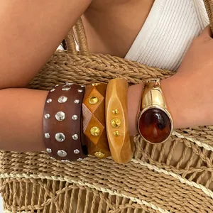 Detailansicht von Retro-Armbändern mit Metallnieten und einem Bernstein-Harzstein am Arm
