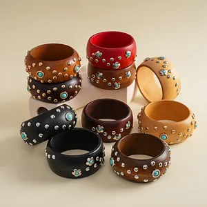 Nahaufnahme von Holzarmreifen im Boho-Stil mit Blumenmotiven und Metallnieten