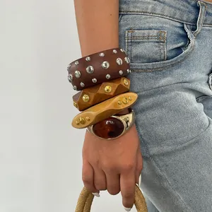 Nahaufnahme von gestapelten Retro-Harzarmreifen mit Metallnieten im Vintage-Boho-Stil