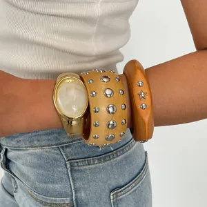 Nahaufnahme von Vintage-Harz- und Metallnietenarmbändern am Arm für einen Ethno-Look