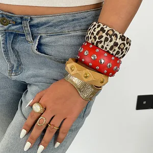 Nahaufnahme von Retro-Harz- und Metallnieten-Armreifen mit Vintage-Ringen am Handgelenk